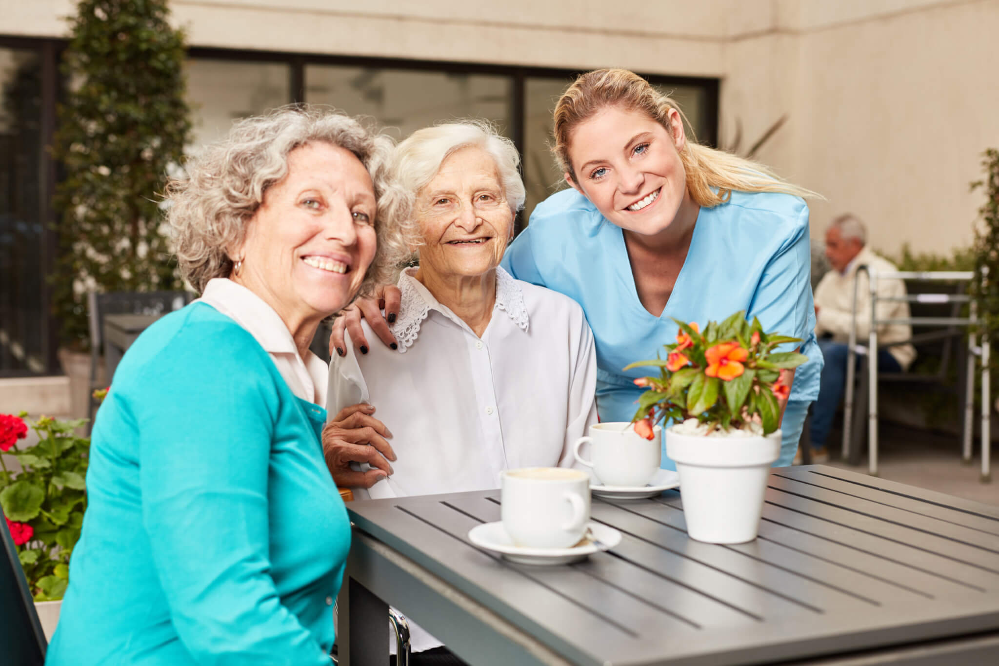 Two,Senior,Women,And,A,Nursing,Assistant,On,The,Terrace