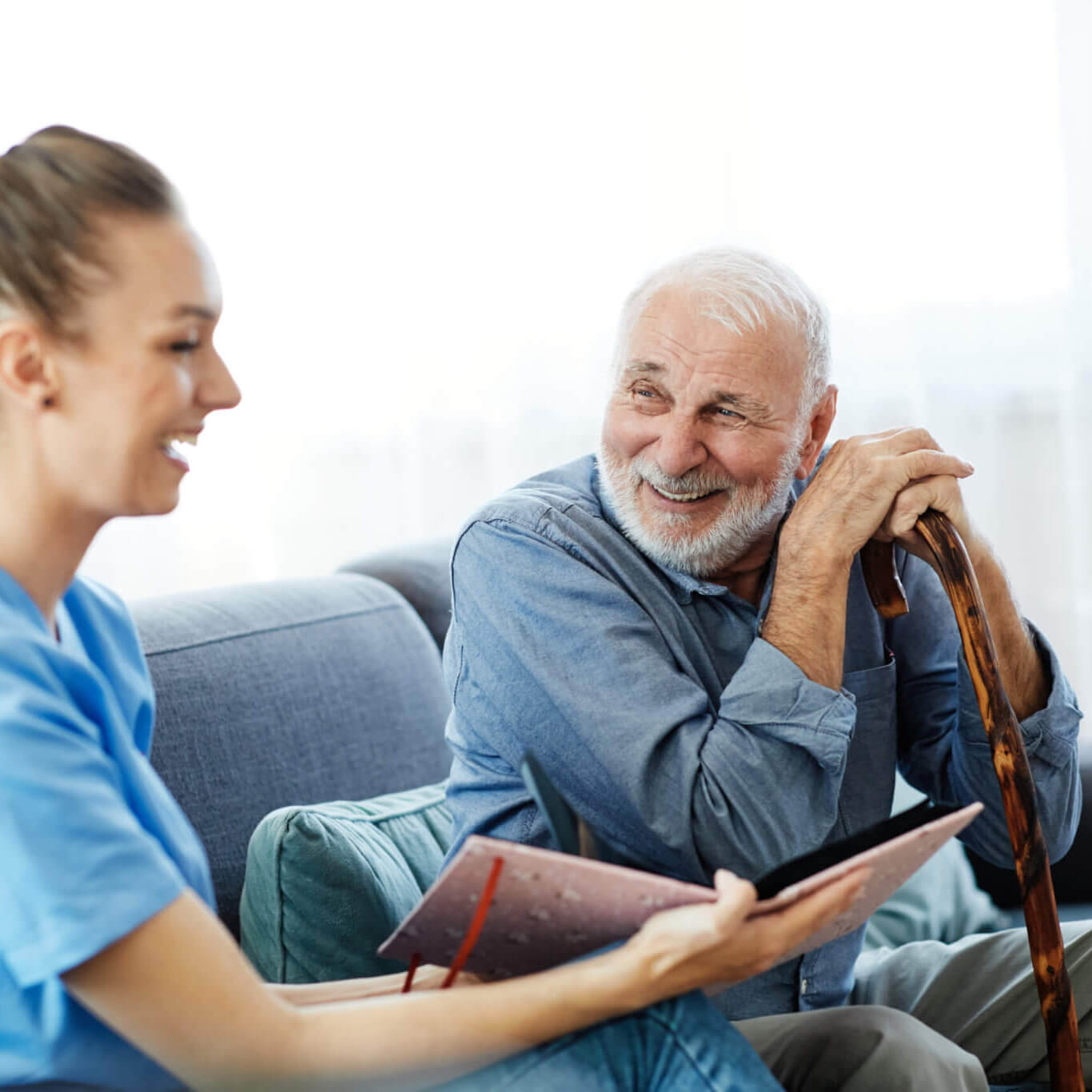 Doctor,Or,Nurse,Caregiver,With,Senior,Man,Looking,At,Photo